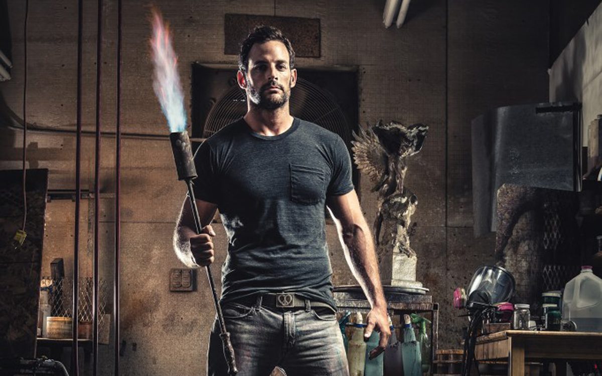 Master patineur Erik Petersen with his lit torch in the studio at The Bronze Age in Prescott, Arizona