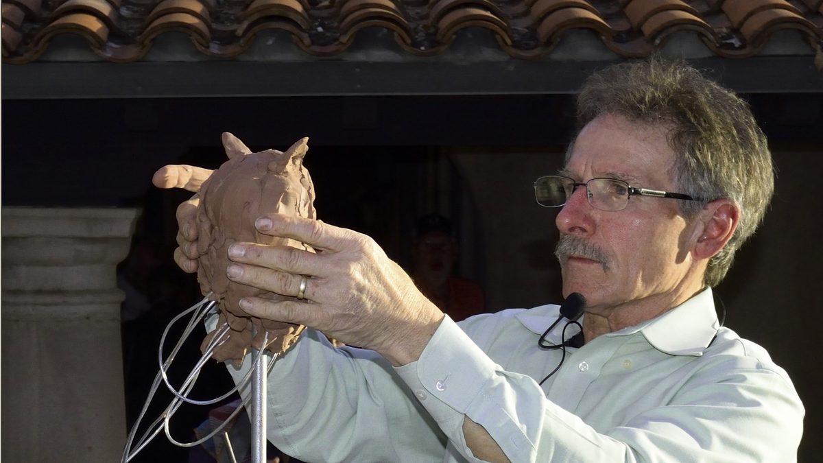 Sculptor Ken Rowe shaping clay over a wire armature during a live quick sculpt at Tlaquepaque, Sedona